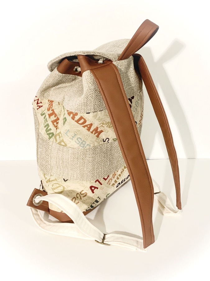 Mochila artesanal de tela con nombres de ciudades del mundo y correas marrones, hecha a mano