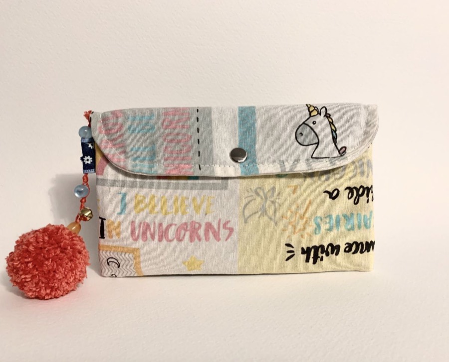Monedero infantil artesanal con unicornios y pompón coral, regalo personalizado hecho a mano